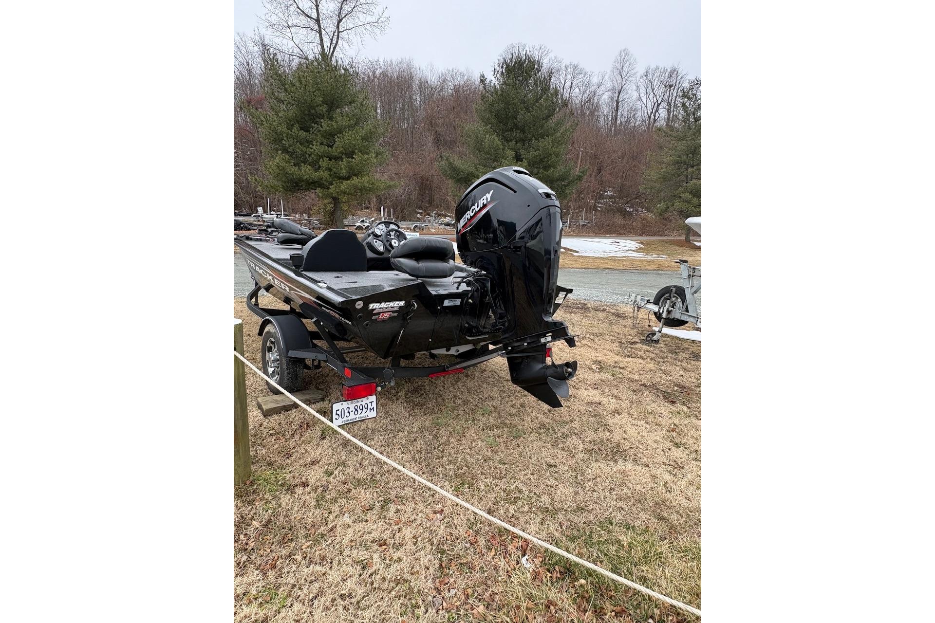 2023 Tracker Pro Team 175 TXW boat with Mercury engine, parked on grass.