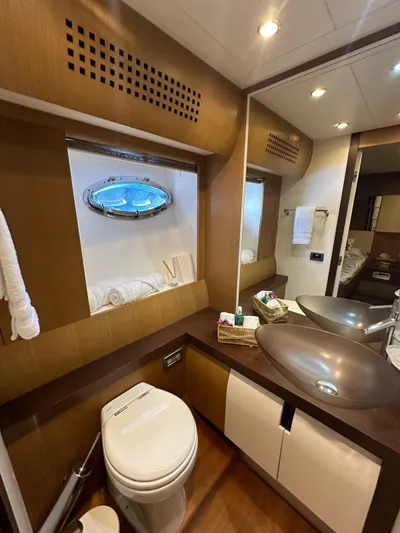  Yacht Photos Pics Luxurious bathroom interior of 2006 Pershing 90 yacht with modern fixtures and porthole window.