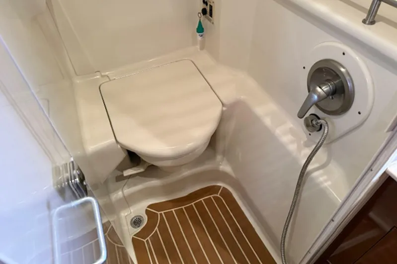  Yacht Photos Pics 2011 Sea Ray Sundancer 370 bathroom with shower and toilet, featuring wood-patterned flooring.