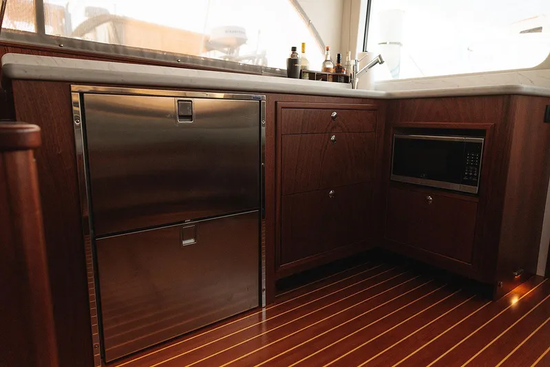  Yacht Photos Pics Luxurious 2022 Composite Yacht CY46 kitchen with wood cabinetry, stainless appliances, and sleek countertops.