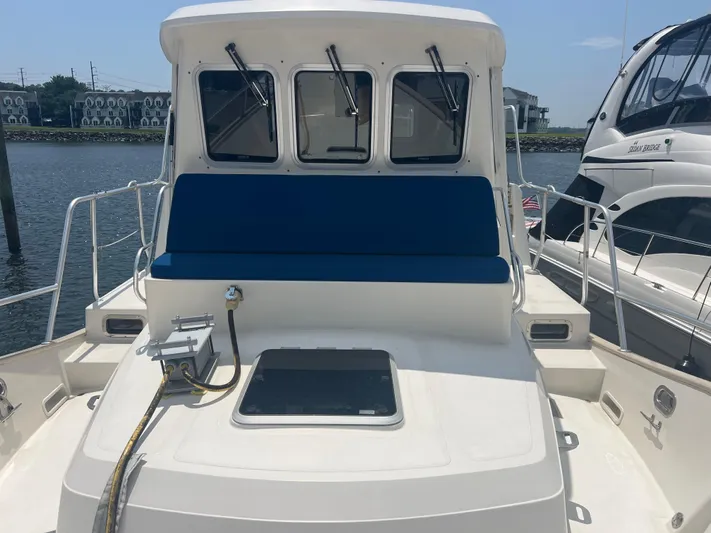 Yacht Photos Pics 1998 Cherubini Independence boat with blue seating, docked near waterfront buildings.