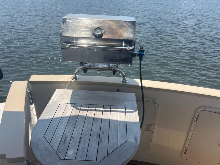  Yacht Photos Pics Outdoor grill on 1998 Cherubini Independence boat with wooden table, overlooking water.