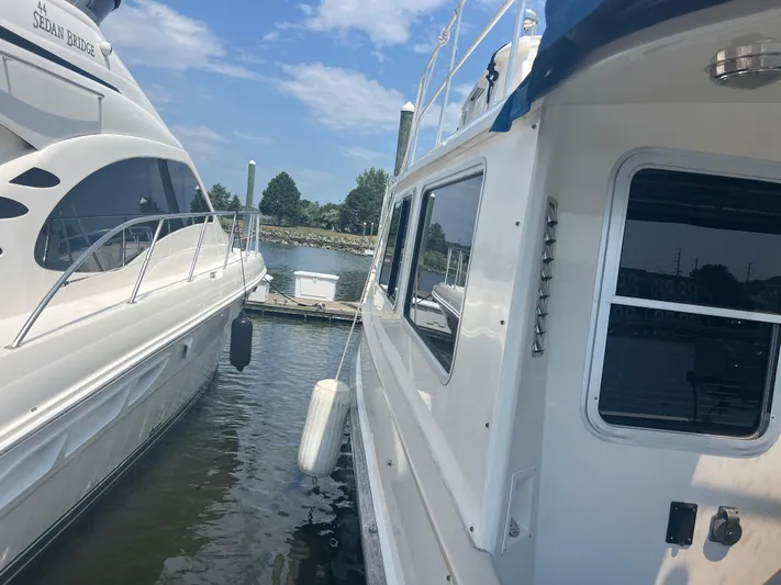  Yacht Photos Pics Two boats docked side by side on a sunny day, featuring a 1998 Cherubini Independence.