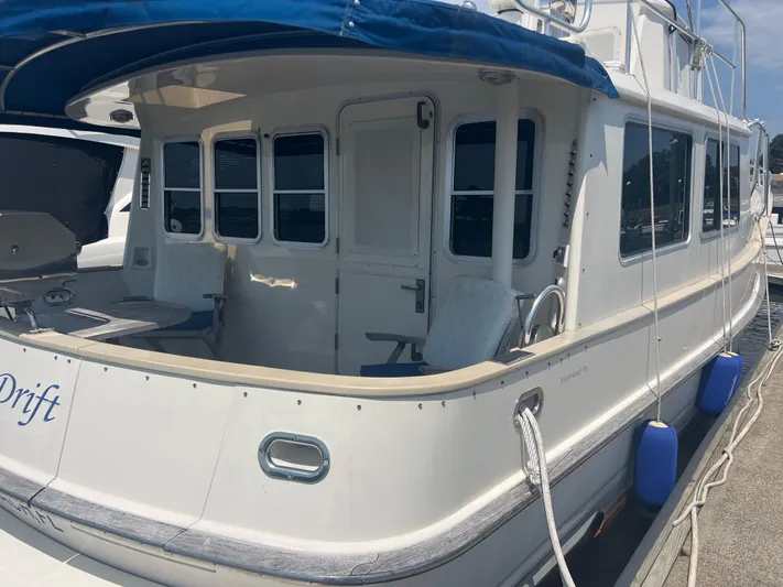  Yacht Photos Pics 1998 Cherubini Independence yacht docked, featuring a spacious deck and blue canopy.