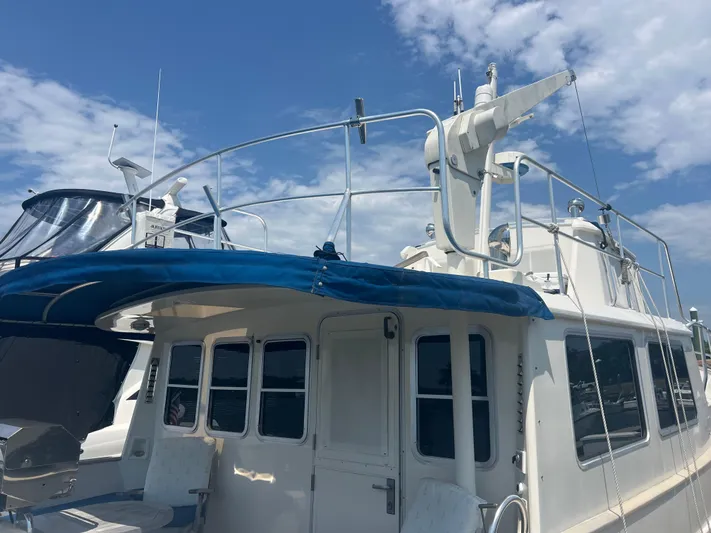  Yacht Photos Pics Cherubini Independence 1998 yacht with blue canopy under a partly cloudy sky.