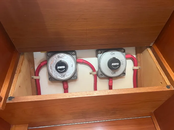  Yacht Photos Pics Battery switches in a 1998 Cherubini Independence boat, featuring red cables and wooden paneling.