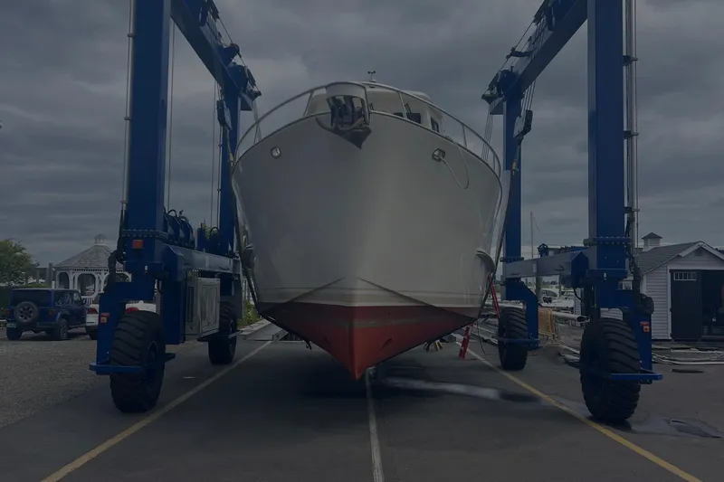  Yacht Photos Pics Cherubini Independence 1998 yacht on a lift at a marina under cloudy skies.