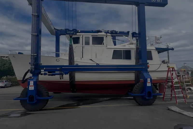  Yacht Photos Pics 1998 Cherubini Independence boat on a lift at a marina, under cloudy skies.
