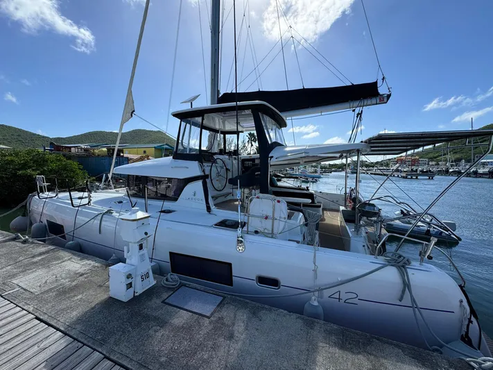 Bluevana Yacht Photos Pics 2023 Lagoon 42 catamaran docked at marina under clear blue sky.