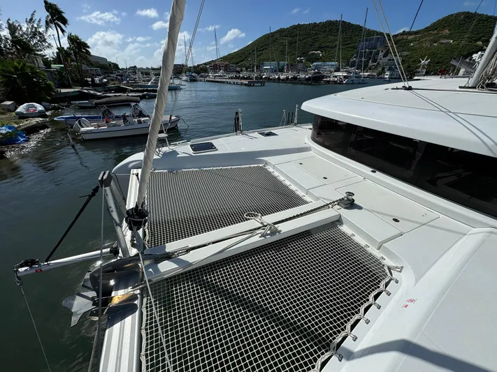 Bluevana Yacht Photos Pics 2023 Lagoon 42 catamaran docked in a scenic marina with lush hills in the background.