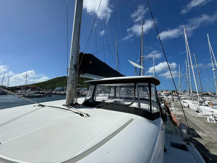 Bluevana Yacht Photos Pics 2023 Lagoon 42 catamaran docked at marina under clear blue sky.