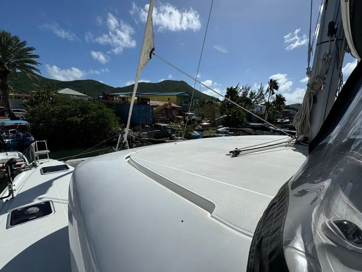 Bluevana Yacht Photos Pics 2023 Lagoon 42 catamaran deck with scenic mountain and sky backdrop.