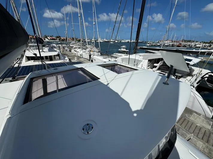 Bluevana Yacht Photos Pics 2023 Lagoon 42 catamaran docked at marina under clear blue sky.
