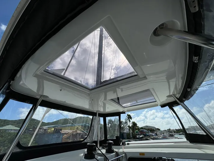 Bluevana Yacht Photos Pics 2023 Lagoon 42 yacht interior with skylight, showcasing modern design and scenic marina view.