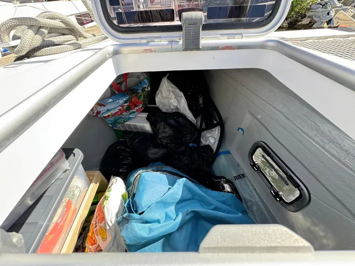 Bluevana Yacht Photos Pics Storage compartment on a 2023 Lagoon 42 yacht filled with various items.