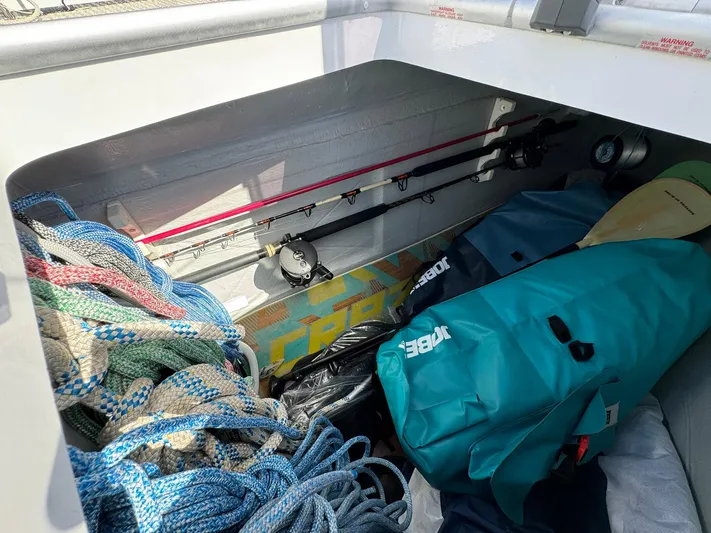 Bluevana Yacht Photos Pics Storage compartment of 2023 Lagoon 42 with ropes, fishing rods, and gear bags.
