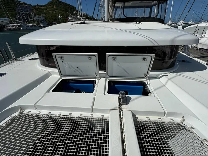 Bluevana Yacht Photos Pics 2023 Lagoon 42 catamaran deck with open hatches, marina background.