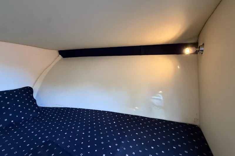  Yacht Photos Pics 2018 Chris-Craft Capri 27 cabin interior with patterned bedding and wall light.