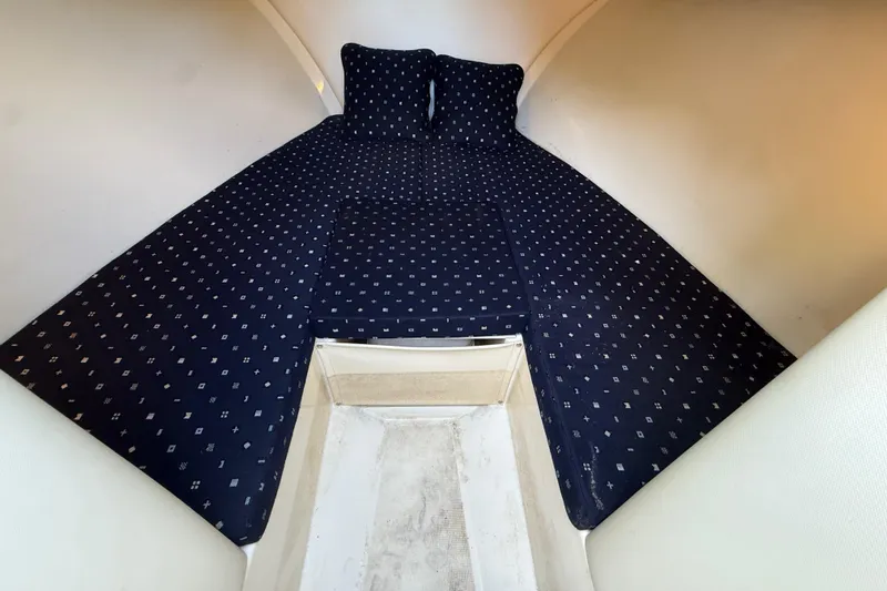  Yacht Photos Pics 2018 Chris-Craft Capri 27 cabin interior with patterned bedding and pillows.