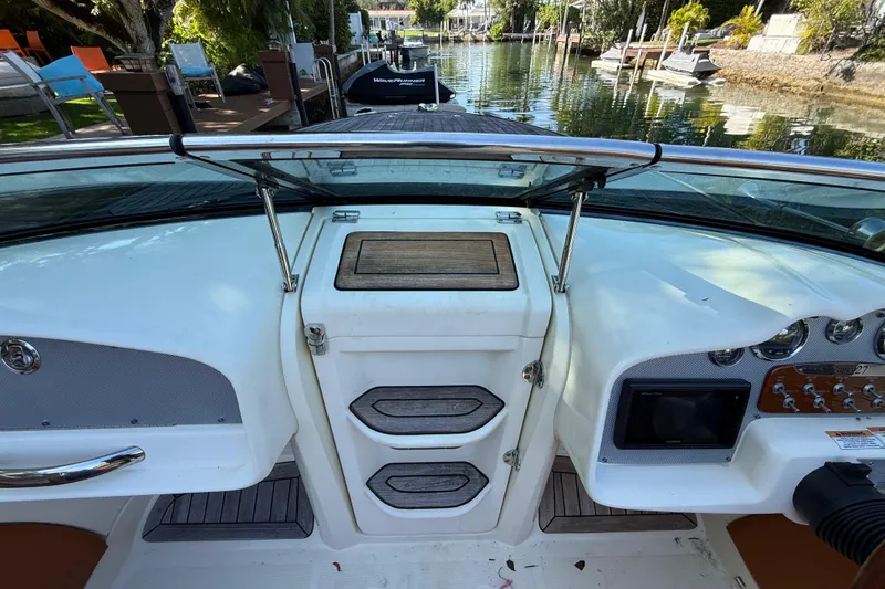  Yacht Photos Pics 2018 Chris-Craft Capri 27 boat dashboard with controls and storage compartments.