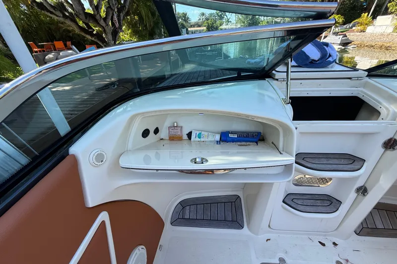  Yacht Photos Pics 2018 Chris-Craft Capri 27 interior with storage compartment and open deck view.