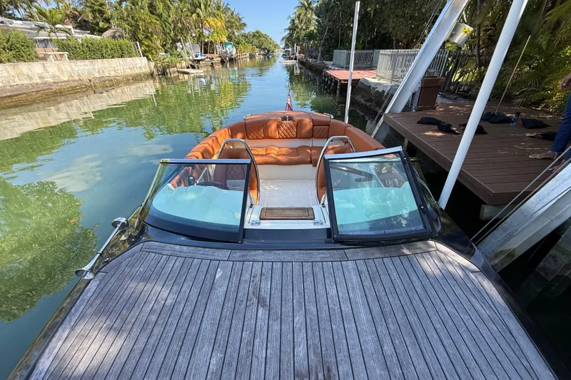  Yacht Photos Pics 2018 Chris-Craft Capri 27 boat docked on a serene canal with lush greenery.