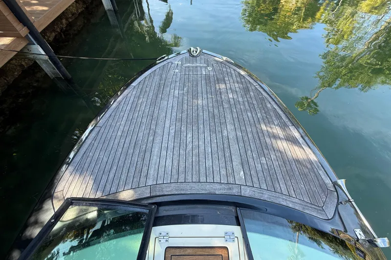  Yacht Photos Pics 2018 Chris-Craft Capri 27 boat deck with wooden finish, docked on calm water.