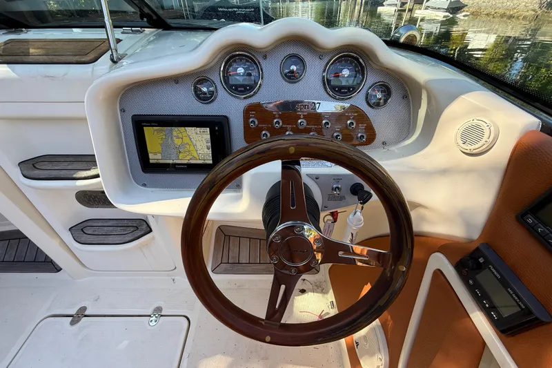  Yacht Photos Pics 2018 Chris-Craft Capri 27 dashboard with wooden steering wheel and navigation system.