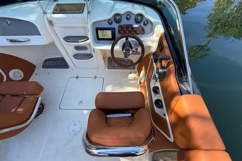  Yacht Photos Pics 2018 Chris-Craft Capri 27 cockpit with brown leather seats and modern dashboard controls.