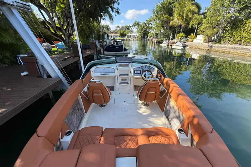  Yacht Photos Pics 2018 Chris-Craft Capri 27 boat interior with tan seating, docked in a scenic canal.