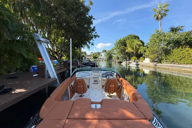  Yacht Photos Pics 2018 Chris-Craft Capri 27 boat docked on a scenic, tree-lined waterway.