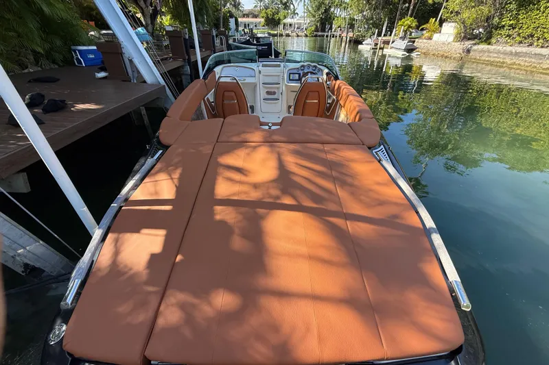  Yacht Photos Pics 2018 Chris-Craft Capri 27 boat with tan upholstery docked on a serene canal.