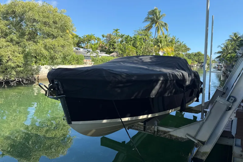  Yacht Photos Pics 2018 Chris-Craft Capri 27 boat covered, docked by tropical waterfront.