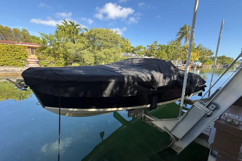  Yacht Photos Pics 2018 Chris-Craft Capri 27 boat covered and docked by a scenic waterfront.