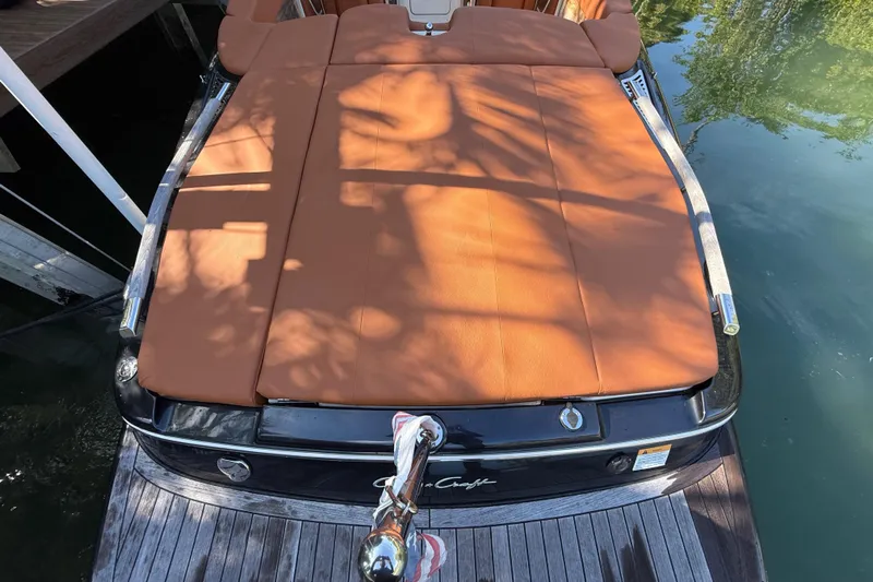  Yacht Photos Pics 2018 Chris-Craft Capri 27 boat with tan leather seating, docked on calm water.