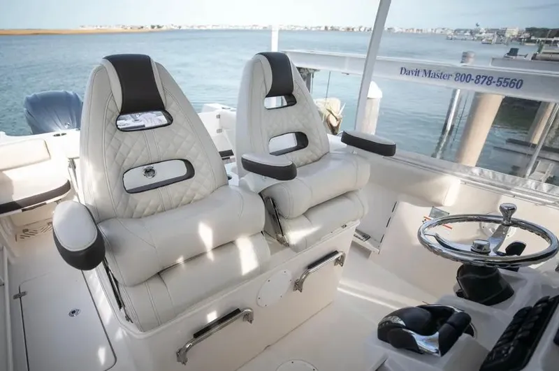  Yacht Photos Pics Luxurious 2022 Sailfish 290 CC boat interior with plush seating and steering wheel.