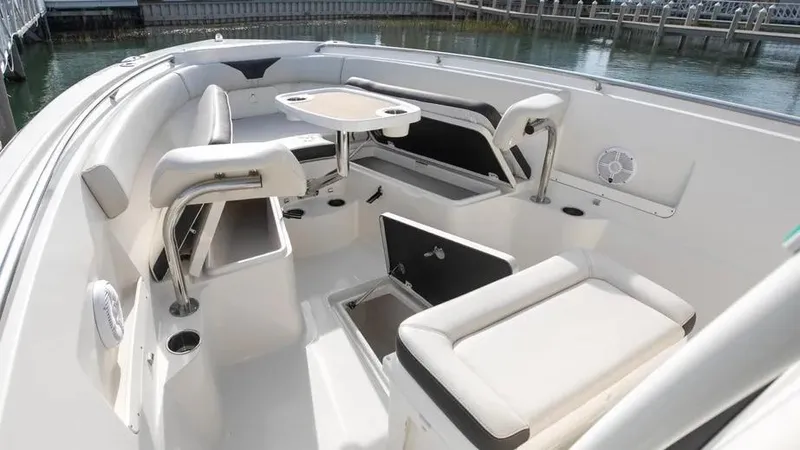  Yacht Photos Pics 2022 Sailfish 290 CC boat interior with seating and table, docked by the water.