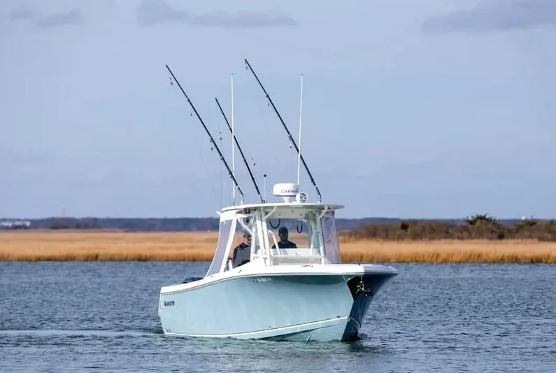  Yacht Photos Pics 2022 Sailfish 290 CC boat on calm water with fishing rods.
