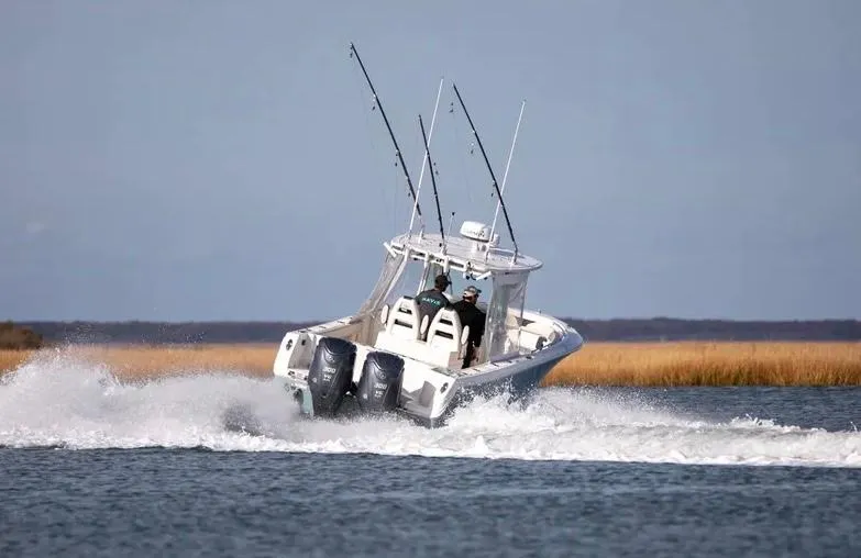  Yacht Photos Pics 2022 Sailfish 290 CC boat cruising on open water with fishing rods.