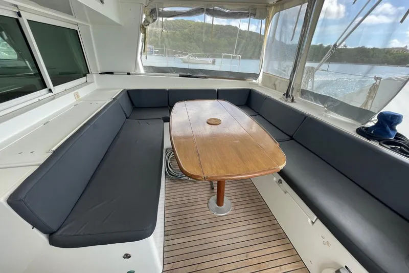 Tikiaora Yacht Photos Pics Spacious Lagoon 500 yacht cockpit with wooden table and cushioned seating, 2008 model.