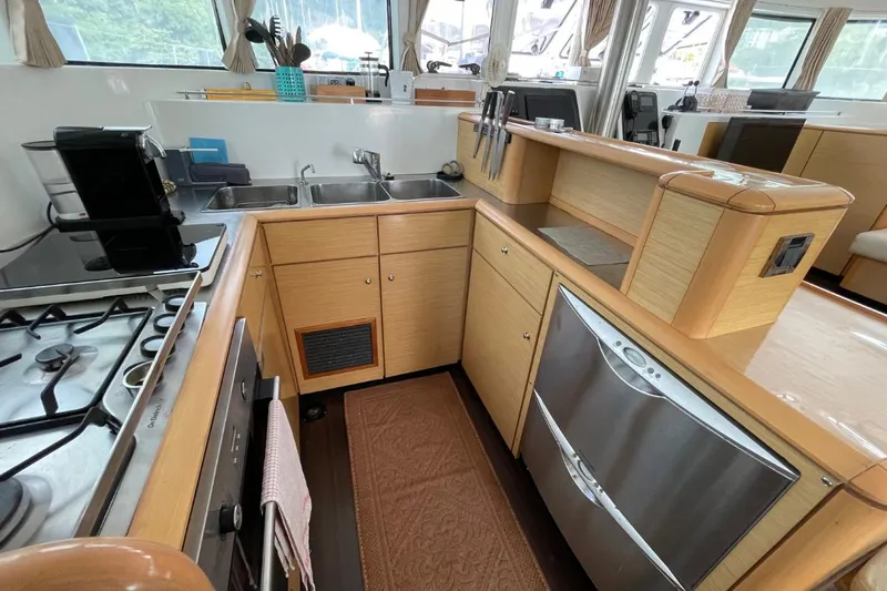 Tikiaora Yacht Photos Pics Modern kitchen in a 2008 Lagoon 500 yacht with appliances and wooden cabinetry.
