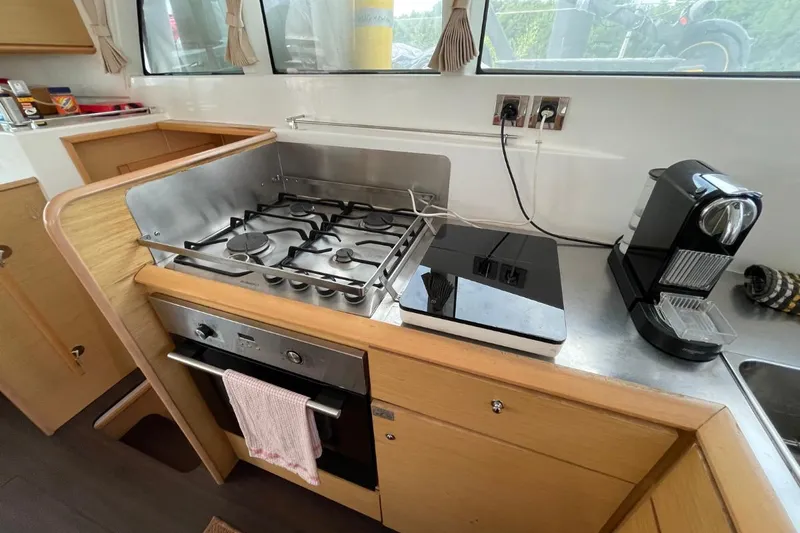 Tikiaora Yacht Photos Pics Modern kitchen in a 2008 Lagoon 500 yacht with stove, oven, and coffee maker.