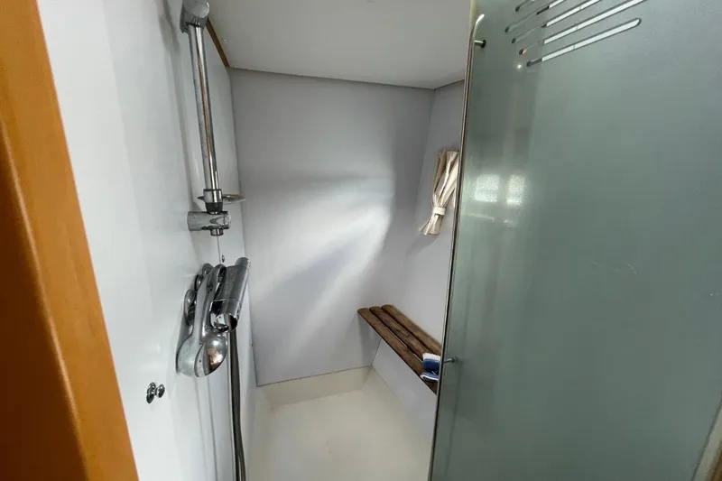 Tikiaora Yacht Photos Pics Shower area in 2008 Lagoon 500 yacht with glass door and wooden bench.
