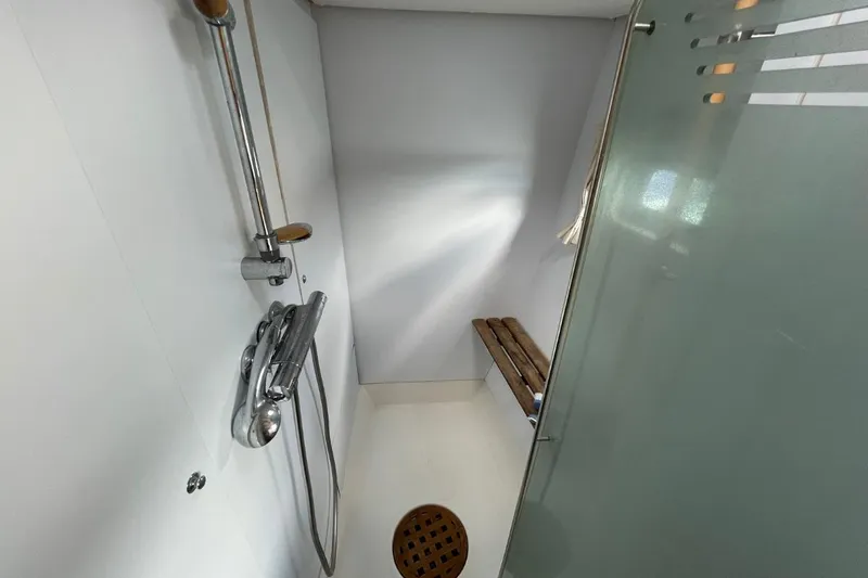 Tikiaora Yacht Photos Pics Shower area in 2008 Lagoon 500 yacht with glass door and wooden bench.
