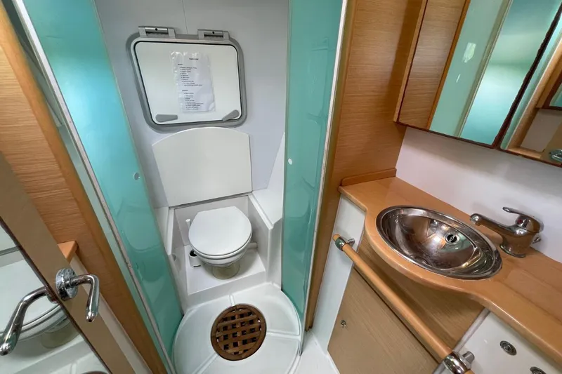 Tikiaora Yacht Photos Pics Bathroom interior of 2008 Lagoon 500 yacht with toilet, sink, and wooden accents.