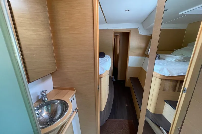 Tikiaora Yacht Photos Pics Interior of 2008 Lagoon 500 yacht with wooden cabinetry and cozy sleeping quarters.