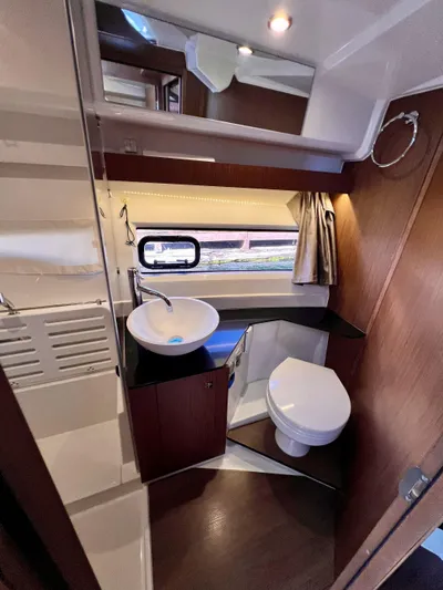  Yacht Photos Pics 2019 Jeanneau NC 1095 boat bathroom with modern sink, toilet, and wood accents.