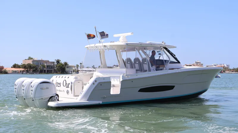  Yacht Photos Pics 2022 Regal 38 SAV boat cruising on a sunny day in coastal waters.