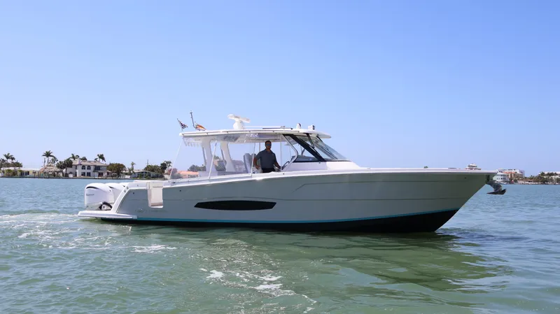  Yacht Photos Pics 2022 Regal 38 SAV boat cruising on calm waters under clear blue sky.