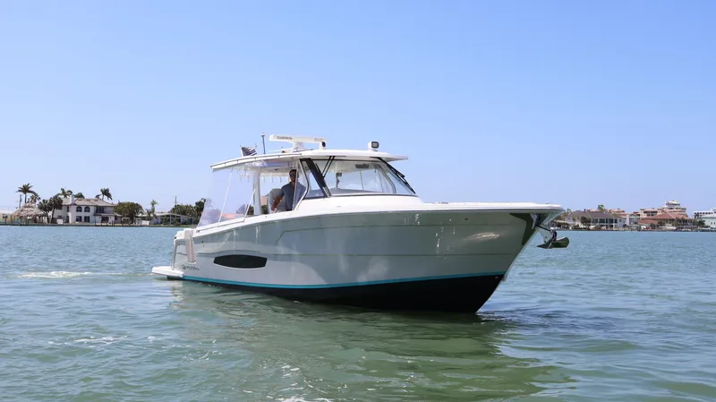  Yacht Photos Pics 2022 Regal 38 SAV boat cruising on calm waters under clear blue sky.
